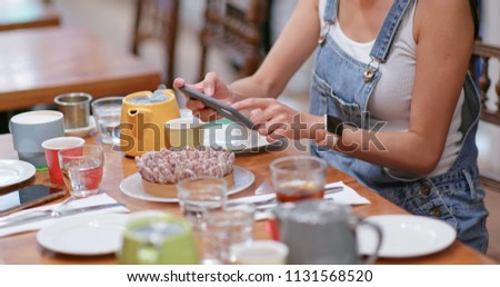 Woman take photo of the cake in coffee shop