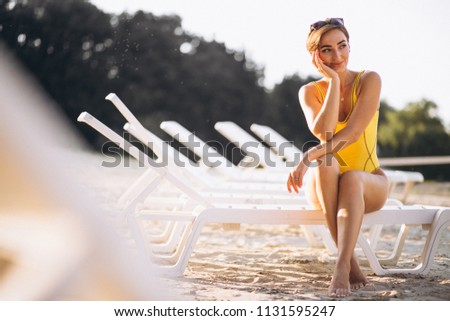 Woman sitting on pool bed by the sea