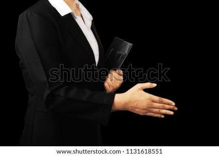 Businesswoman in black suit offering to shake the hand isolated on black background, clipping path.