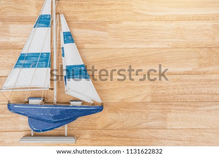 Preparation for Traveling concept. Sailboat on a vintage wooden background with copy space.Traveling background concept.