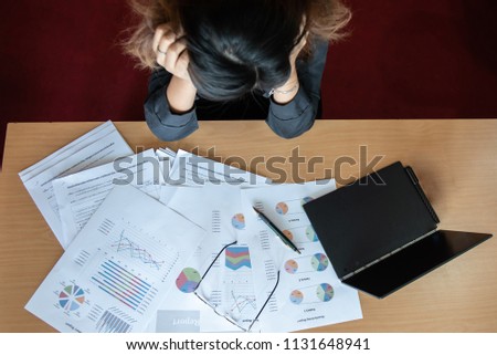 Overworked and tired businesswoman sleeping over a desk at work in her office. with a lot of paper.