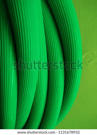 Abstract background of Long Green Water Pipe. Macro. Object. Close up. Abstract background of Green color. Abstract lines. Continuous lines. Plumbing. Irrigation. Industrial. Engineering. Piping. 
