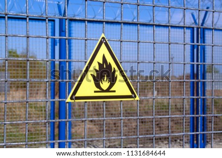 Fire danger yellow sign on metallic grid