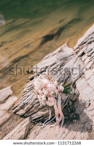 Beautiful wedding bouquet with red roses and berries on the stone background