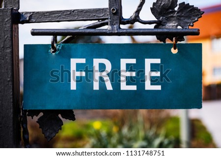 Free word on old green sign on the background of rustic German house. Information for tourists and travelers about available rooms in the hotel or apartment