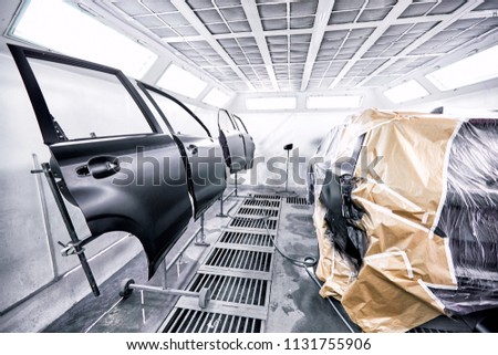 Restoration painting of a black car in the service center. Royalty-Free Stock Photo #1131755906