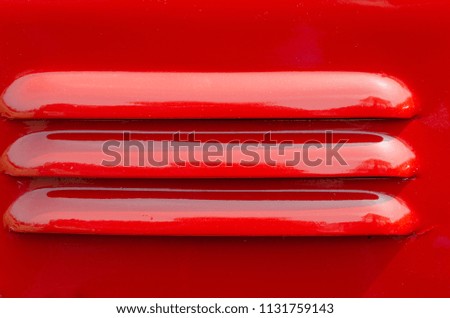 Ventilation slots on a red painted panel
