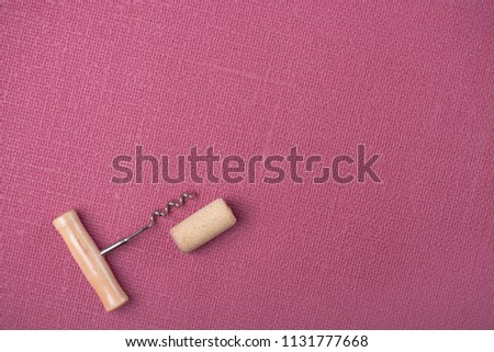 Wine cork stopper and corkscrew on Fuchsia background Copy space Top view