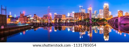 Minneapolis skyline with reflection in river at night.
