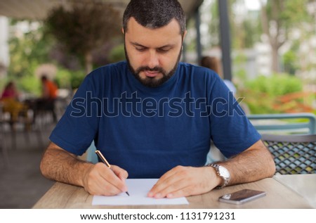Young man writing on paper