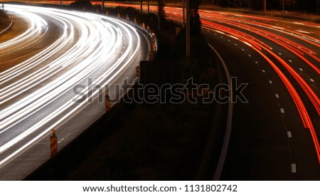 White and red light trails of cars passing by at high speed on the highway in long exposure picture taken from bridge
