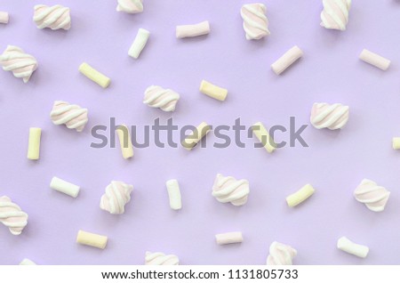 Colorful marshmallow laid out on violet paper background. pastel creative texture. minimal