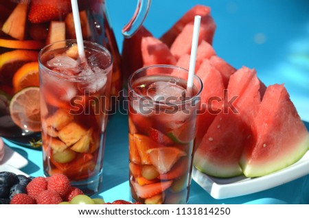 Pool party with sangria pitcher, fruit cocktails and refreshments by the swimming pool. Summer lifestyle, fun and relaxation theme. Stay at home vacation.