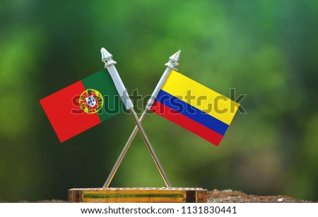 Colombia and Portugal small flag with blur green background