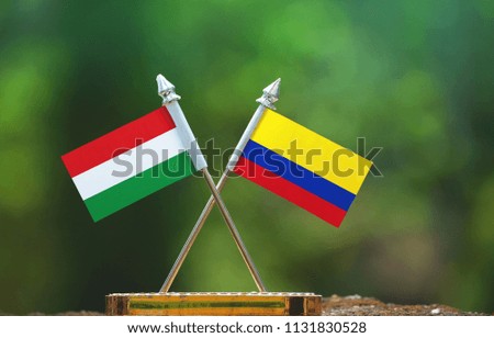 Colombia and Hungary small flag with blur green background