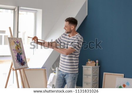 Male artist painting in workshop