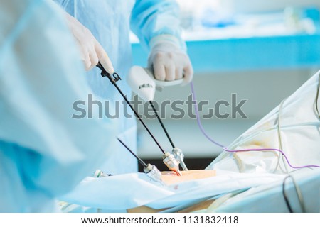 Close up of hands of surgeons team during operation uterus removal with surgical laparoscopy instruments. Gynecology. Royalty-Free Stock Photo #1131832418
