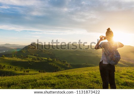 Woman taking photo on mobile phone at the mountain peak.