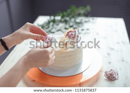 confectioner in a white apron on a dark background with a cake