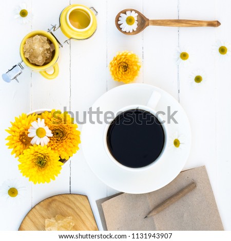 Cup of Coffee and Summer Calendula and Chamomile Flowers