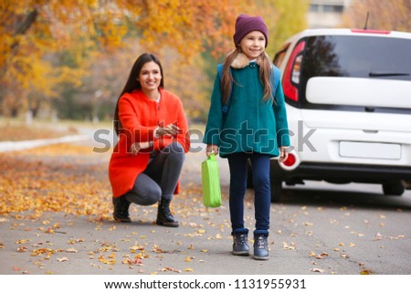 Young mother seeing her daughter off to school