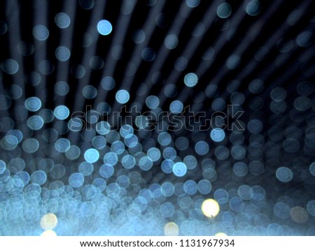 Blurred strings of lights create blue bokeh.
