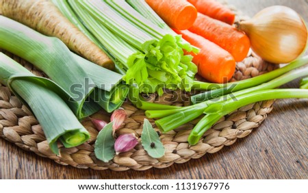 Fresh vegetable board - carrot, celery, leek, chili, onion, parsnip, parsley, bay leaf, garlic. Ingredients of broth, soup - cooking. European cuisine.