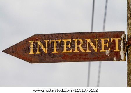 An old, rusty sign directing people towards a location with an Internet connection.