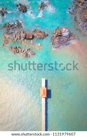 Aerial view of a beach area, consisting of a mini gazebo and stones