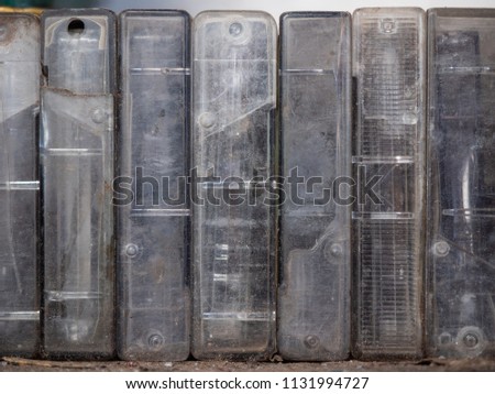 An old audiotapes in dirty plastic boxes, close up view. Background of vintage audio cassettes standing in a row on shelf. Dusty plastic spool holders on a wooden shelf, background