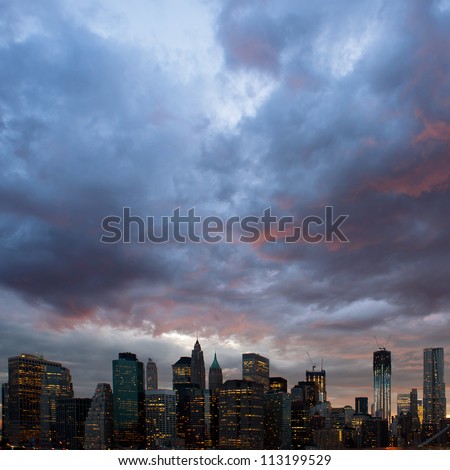 Panoramic shot of Manhattan skyline from the Brooklyn bridge at dusk.