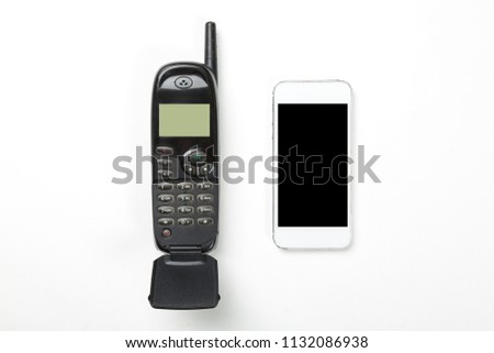 Old retro mobile phone with antenna and modern touch screen phone on white background. Technology concept.
