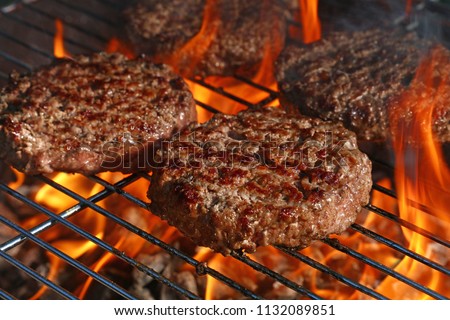 Close up beef or pork meat barbecue burgers for hamburger prepared grilled on bbq fire flame grill, high angle view