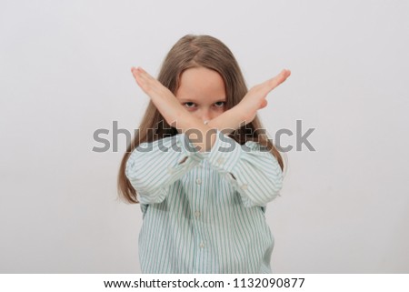 Girl making stop sign with crossed hands. Serious girl denying, refusing any action, looking at camera on white background