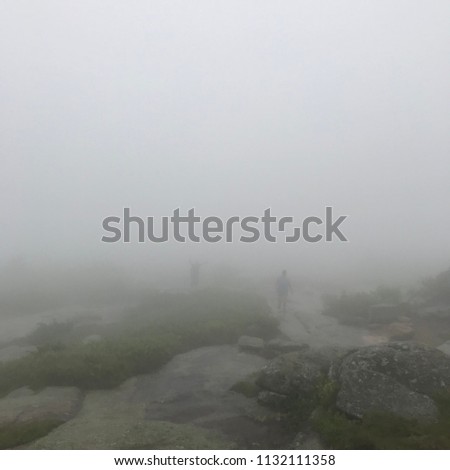 Coming up through the fog, hikers summit Cadillac Mountain in Acadia National Park