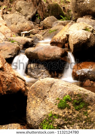 long exposure shot of a stream flowing between rocks in Valle de Ángeles, Honduras. 
