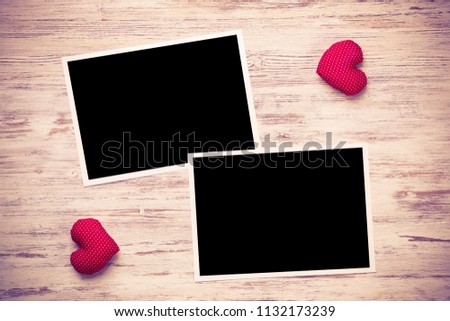 Blank photo frame and love hearts on wooden table