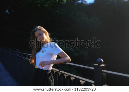 Attractive young blonde woman enjoying active time outdoor in the park with sun light on the background