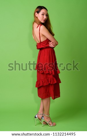 Young beautiful Asian woman against green background