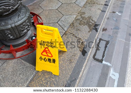 Cleaning in progress and caution wet floor symbol against cleaning in Longshan Buddhist temple in Taipei city, Taiwan