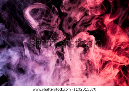 Dense multicolored smoke of   pink, red and purple colors on a black isolated background. Background of smoke vape
