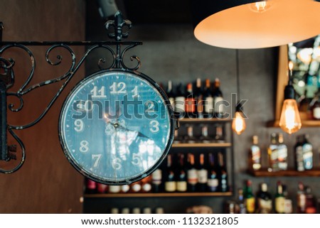 Old, vintage, street, train station or city clock on the wall in front of wines in restaurant, cafe or bar. Vintage Retro Bar or Cafe concept image interior.