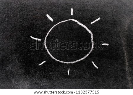 White color chalk hand drawing in sun with light ray shape on blackboard background