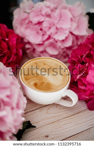 Cup of cappuccino and flowers.