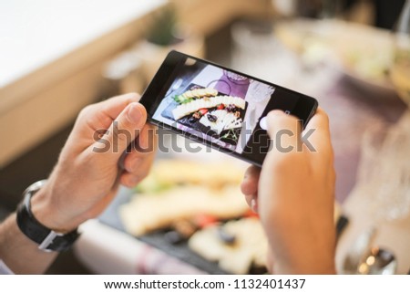Hand taking a picture with a smartphone.