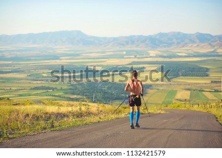 Scandinavian walking. Ultramarathon in the highlands. A man with Scandinavian sticks. Mountain serpentine race Royalty-Free Stock Photo #1132421579