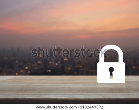 Key icon on wooden table over blur of cityscape on warm light sundown, Business security concept