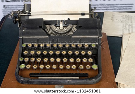 Old vintage typewriter with Russian font and a blank sheet of paper inserted.
