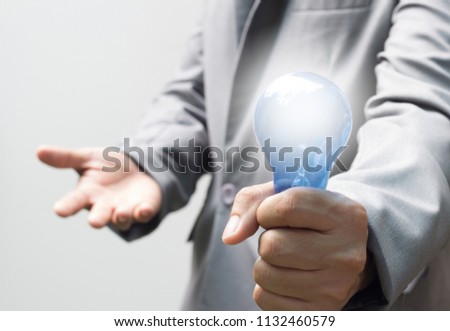Business man in gray suit holding blue light bulb, Power thinking concept