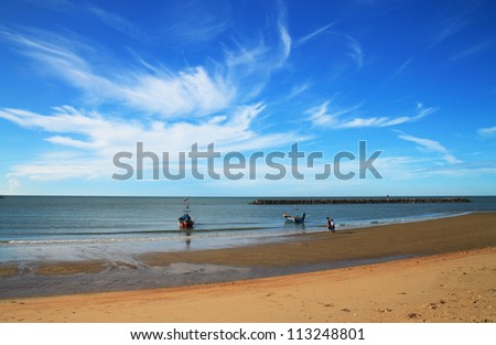Two people on the beach and the boats
